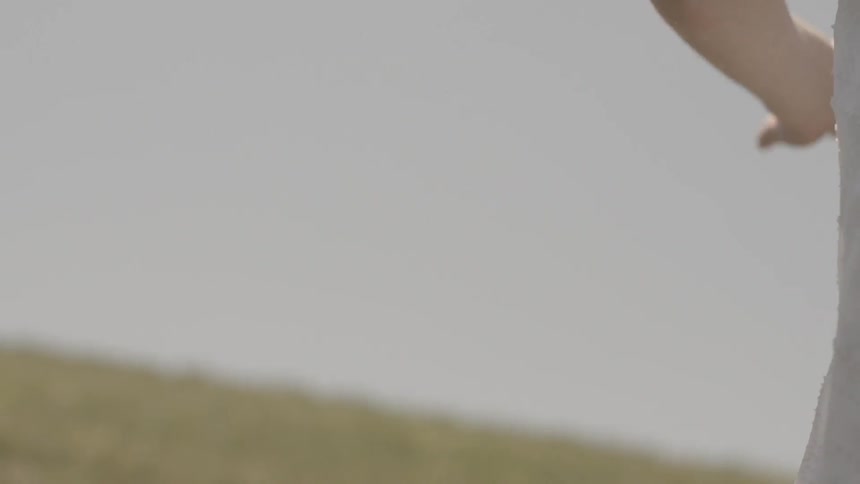 A woman in a white dress running in a field