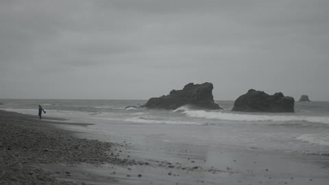 Person walking along the beach on a cloudy day