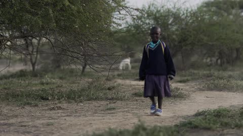 A young girl walks down a path