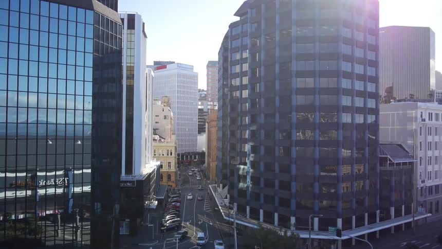 A busy city with traffic moving along and large buildings on a sunny day