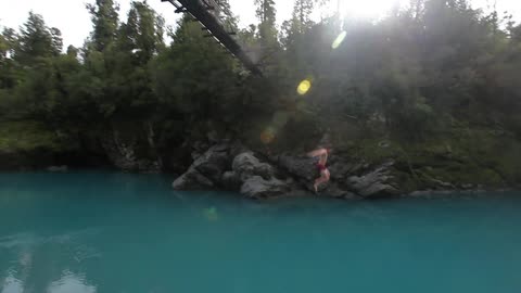 Person jumping from a high bridge into a river