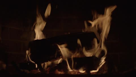 A close view of logs burning in a fireplace
