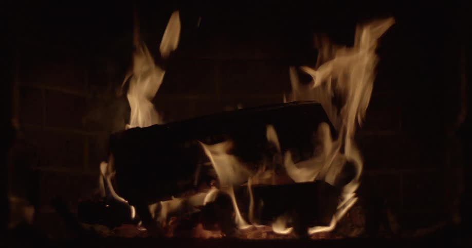 A close view of logs burning in a fireplace
