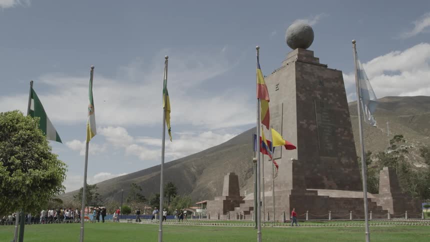 Multiple flags hung beside a large monument
