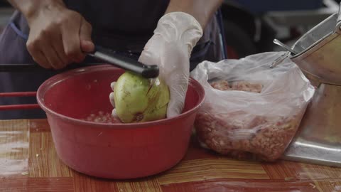 A person hits a fruit to release seeds