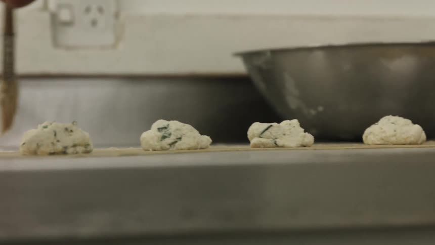 A chef brushing butter on parchment paper