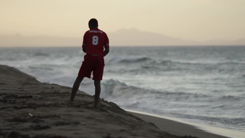A man is playing at the edge of the ocean