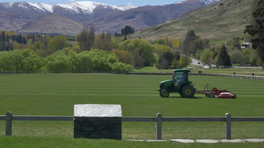 A tractor drives across a farm field