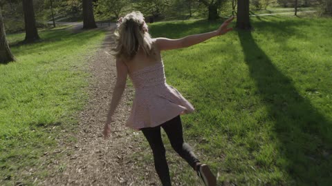 A young girl playfully runs down a path