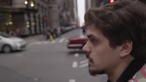 A man crosses a busy city street