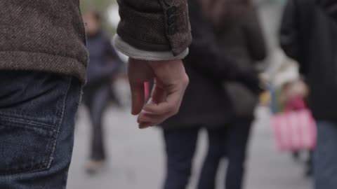 Pedestrians walk down a city sidewalk