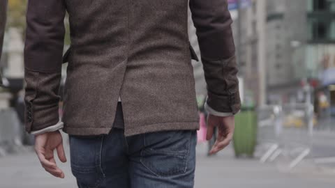 Pedestrians walk down a city sidewalk