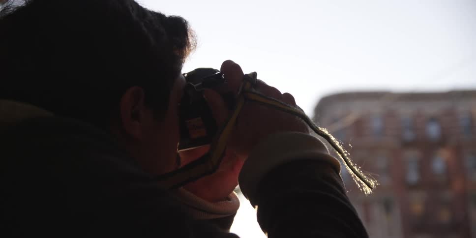A man takes pictures on a city street