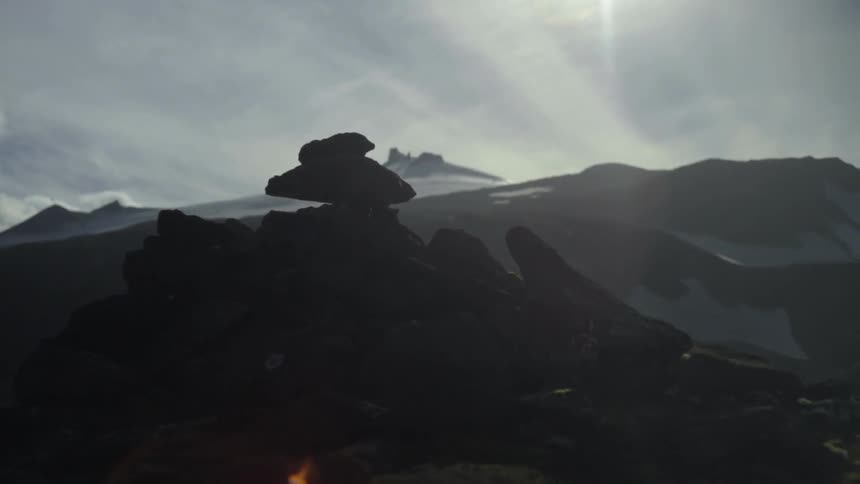 The sun setting behind snow-capped mountains