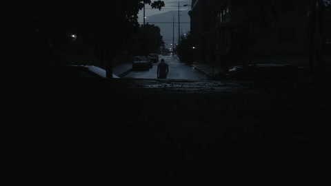 A man walks down a city street at night