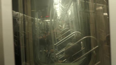 Man doing handstand tricks on a subway train