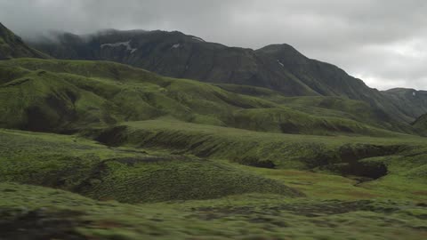 A scenery of a grassfield and mountain