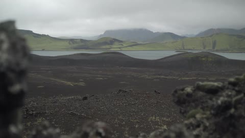 A scenery of a hill and lake at cloudy days