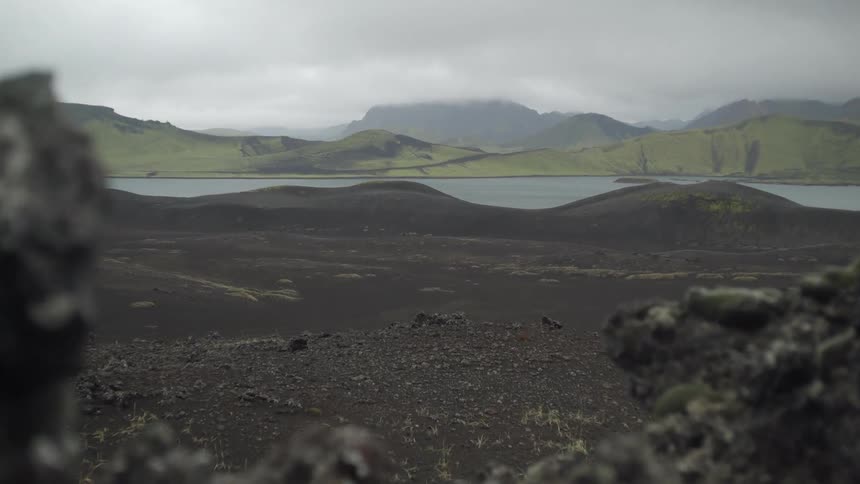 A scenery of a hill and lake at cloudy days