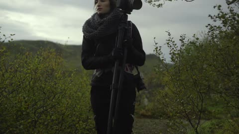 A person walking with a large camera