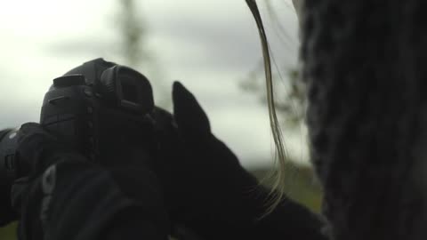 A woman adjusting her camera on a cold day