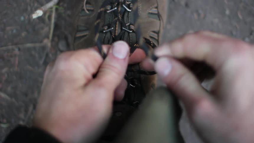 A man tying the laces on his hiking boots