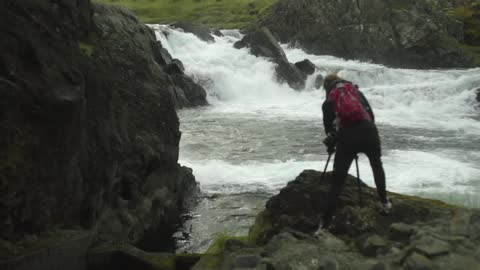 A person standing on the edge of a river