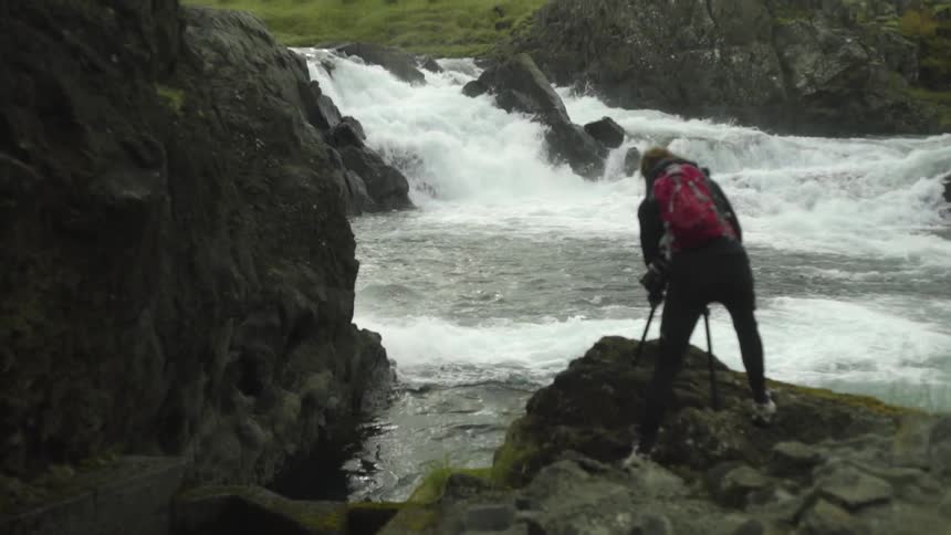 A person standing on the edge of a river
