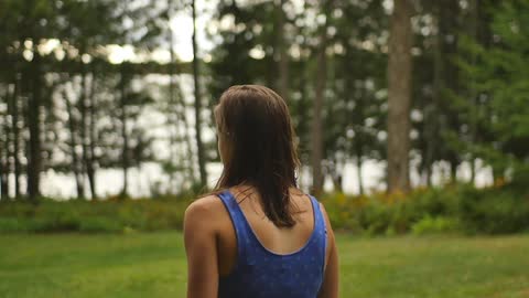 A woman in a vest top walking in a rural area