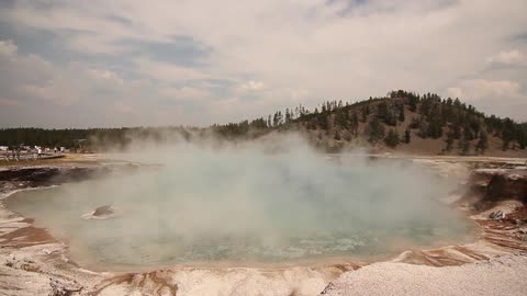 Steam rolls off a geyser