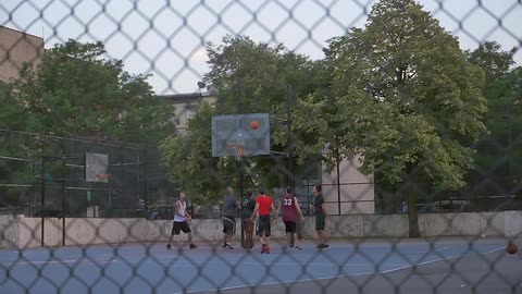 A group of boys play basketball