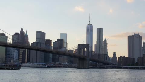 Boats traveling under a bridge leading to a city