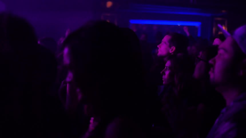 People are watching something in a dark club