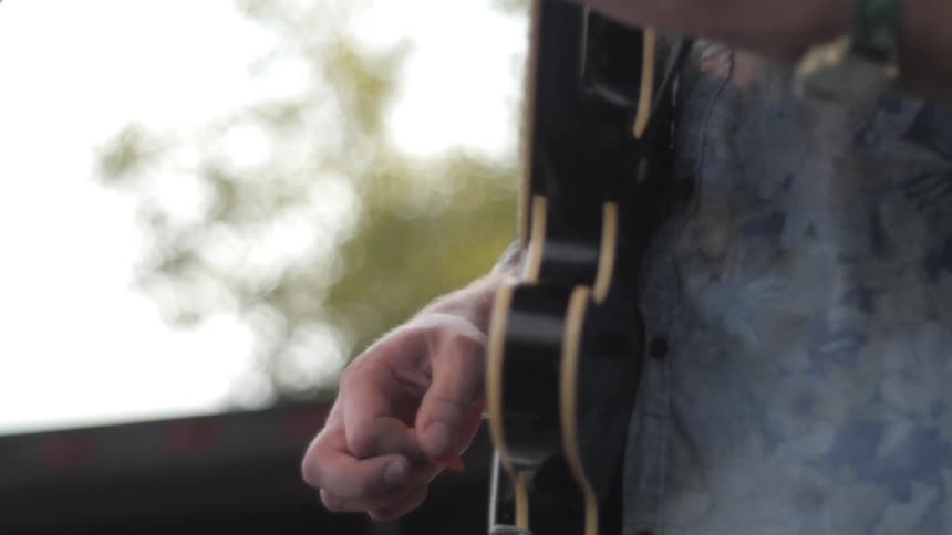 A man strums an electric guitar