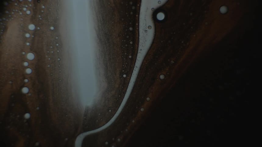 Brown and white liquid flow into each other