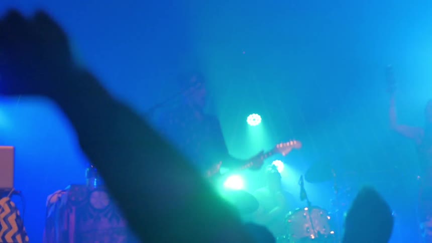 An audience jumps to a live music performance