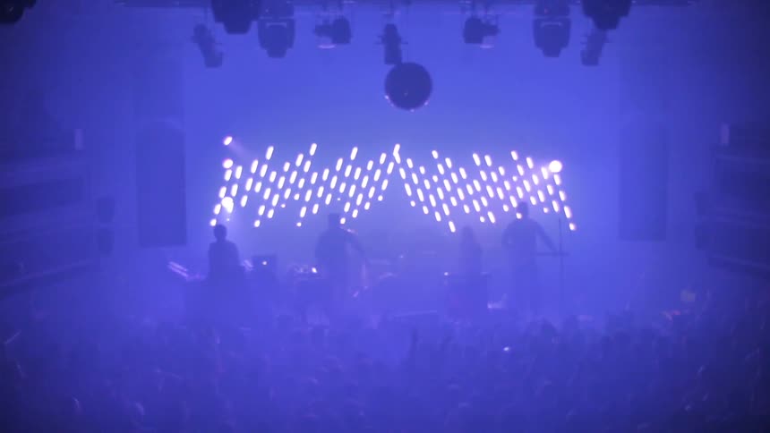 A band playing a concert in front of a cheering crowd
