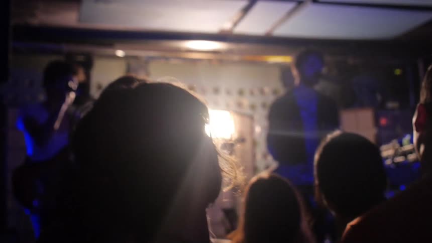 An audience nods along to a band playing onstage