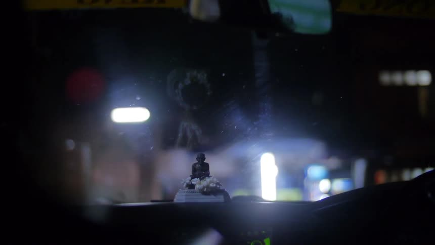 A vehicle drives through an urban area at night