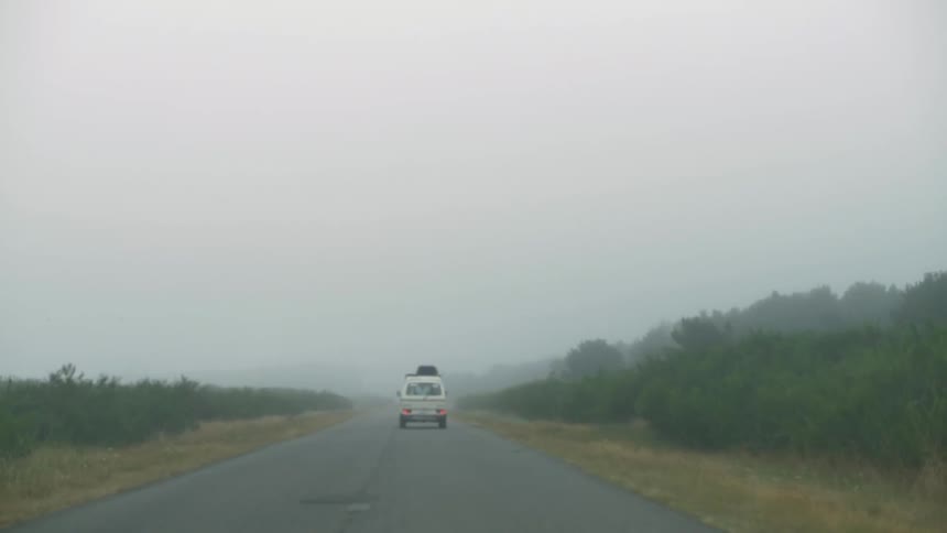 A van drives down a foggy road