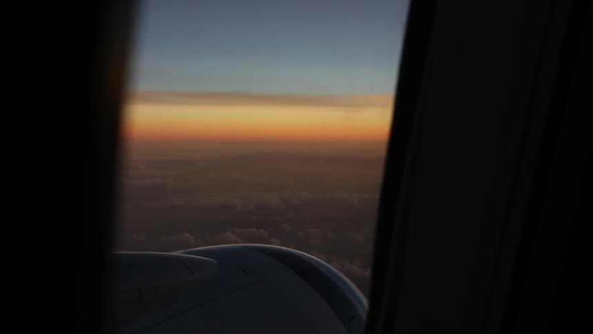 The sun sets out a plane window high in the air