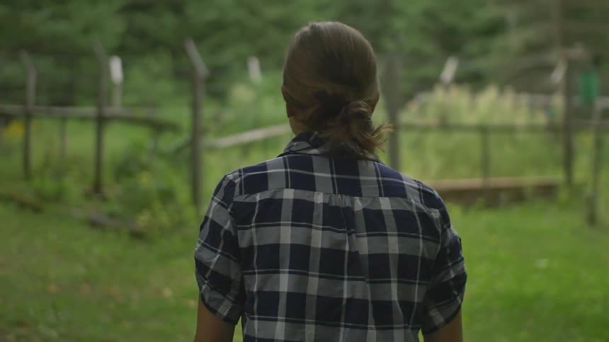 A woman walks on the farm field