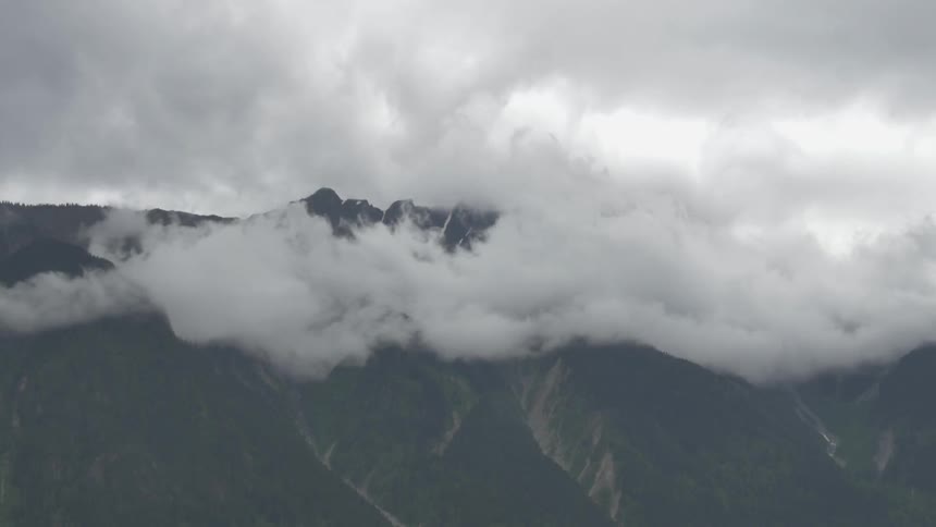 Clouds hovering at a mountain's peaks