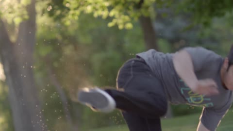 A man jumps and rotates on concrete