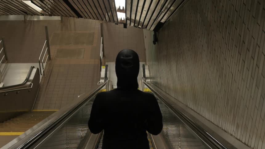 Man descending on an escalator indoors