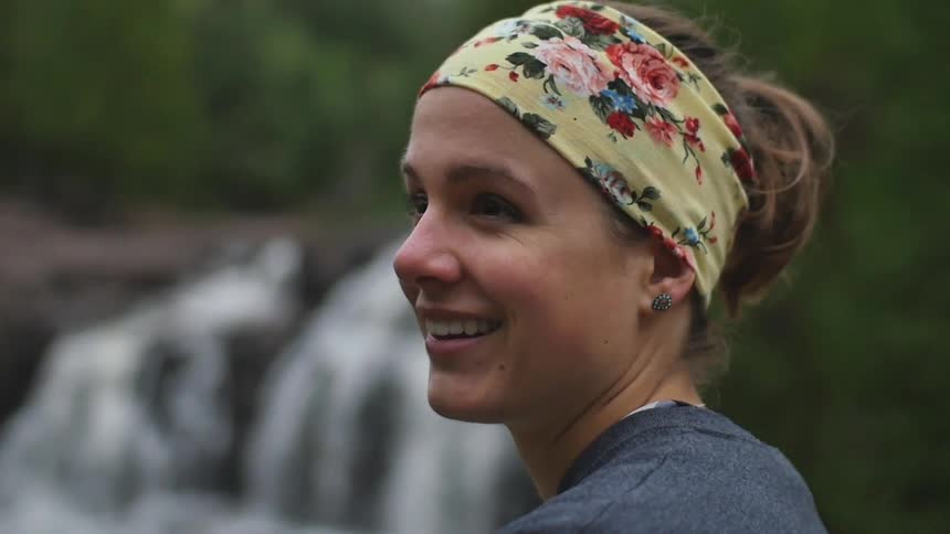 A woman with a headband on smiles