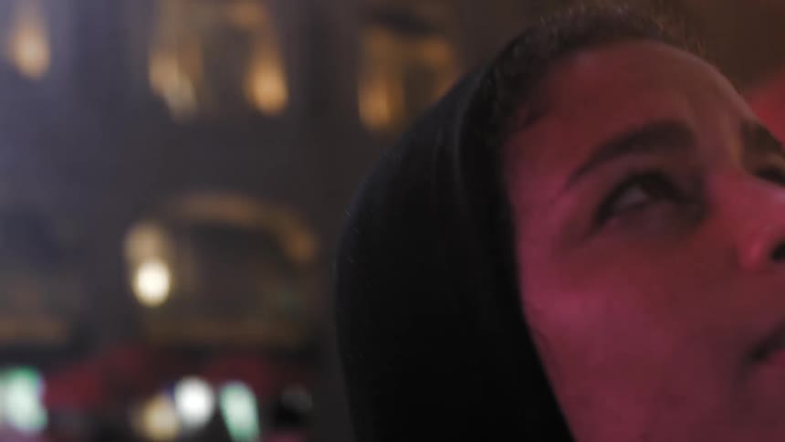 At night a woman looks into the city tops