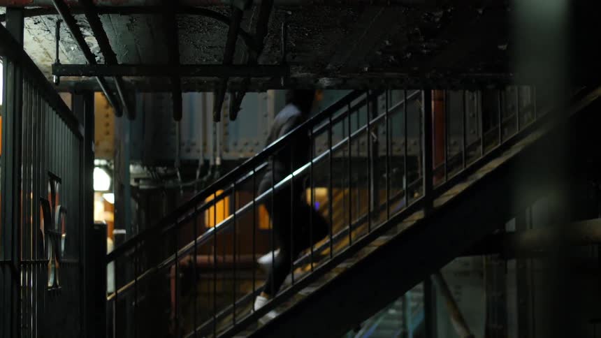 Young woman walking up some metal stairs