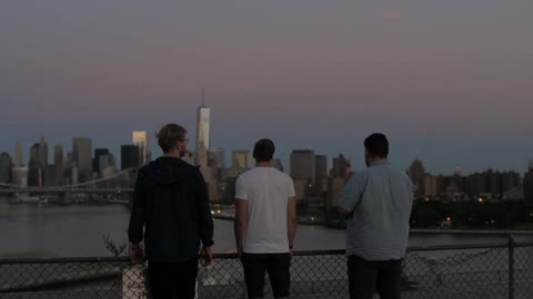 Three man look towards the city