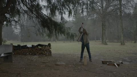 Man chops wood with an ax